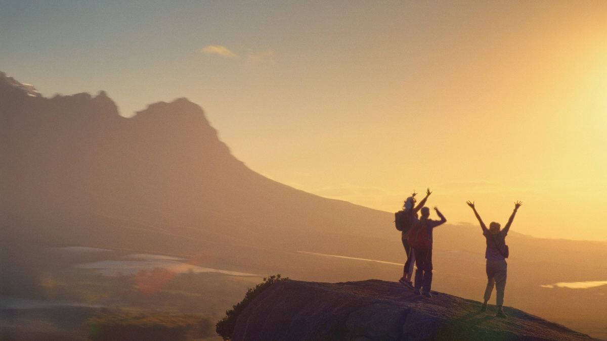 an image of hikers cheering at the top of a mountain