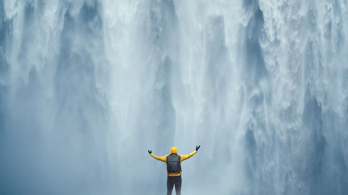 an image of a man standing under a waterfall