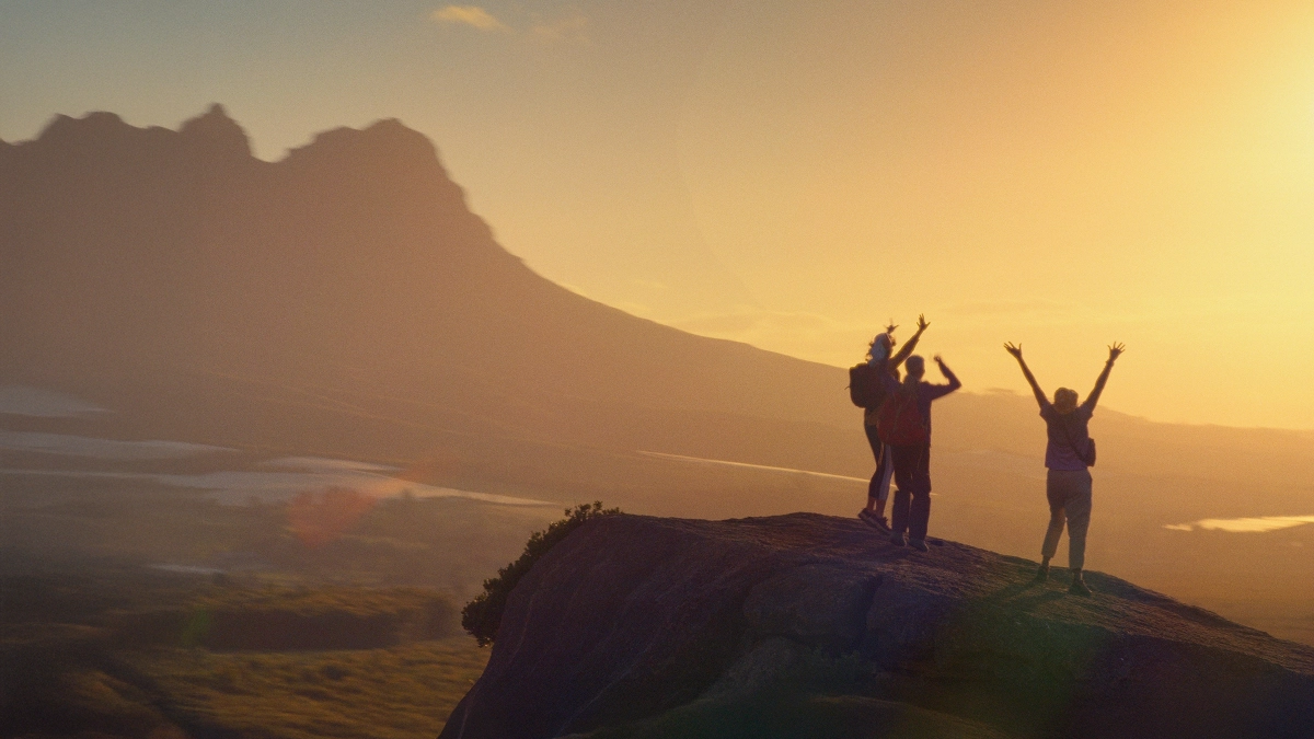 an image of hikers cheering at the top of a mountain