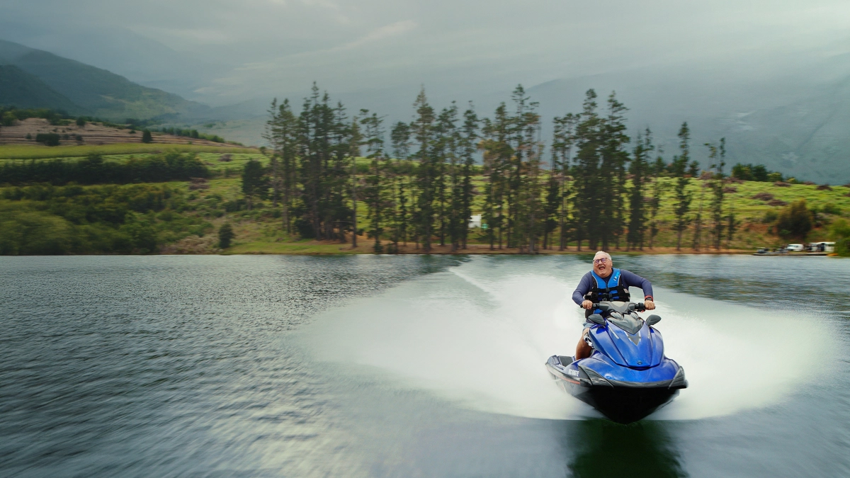 an image of a old man riding a jetski in a river