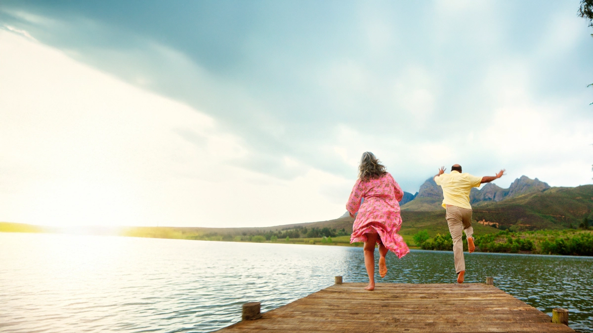 an image of a old couple jumping over a pier