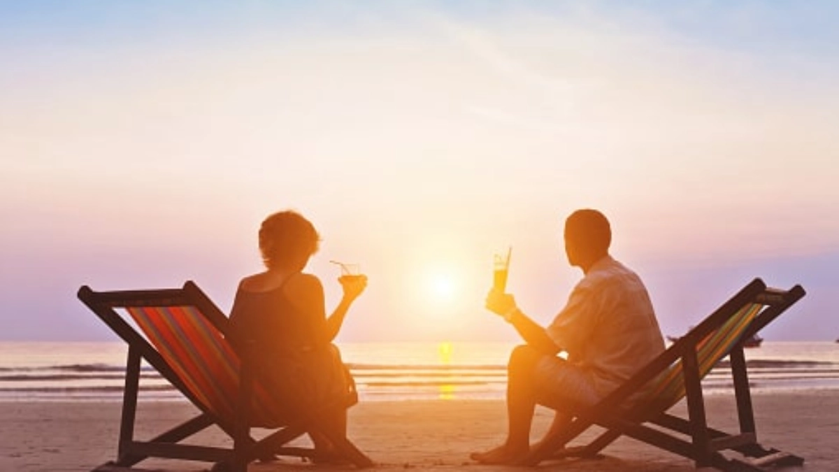 an image of couple sitting on two beach deckchairs