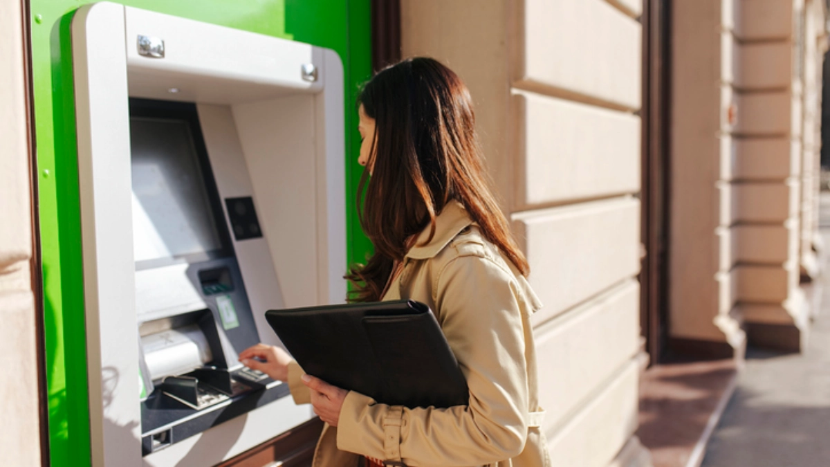an image of a woman using an ATM machine in Europe