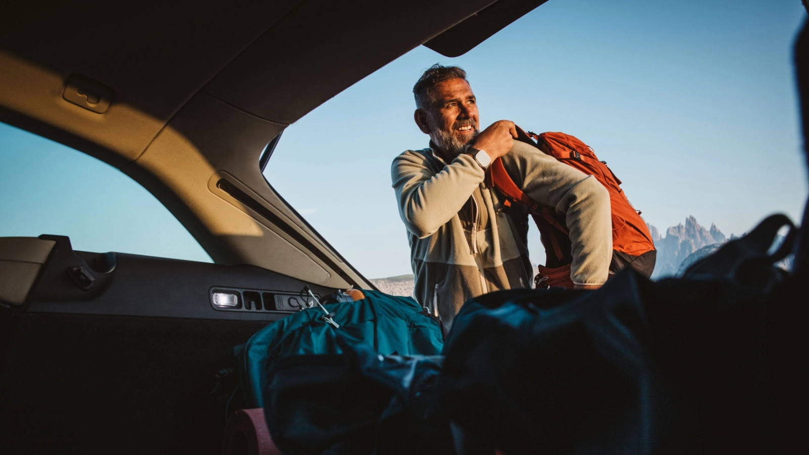 Man with backpack hiking at Dolomite. Standing next to the car, preparing for hiking.
