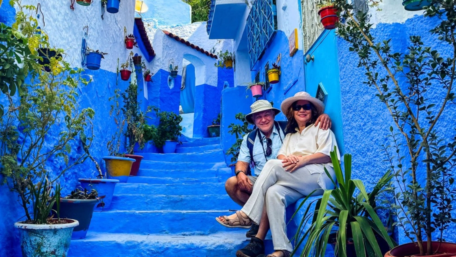 Couple posing on stairway in Chefchaouen, Morocco.
