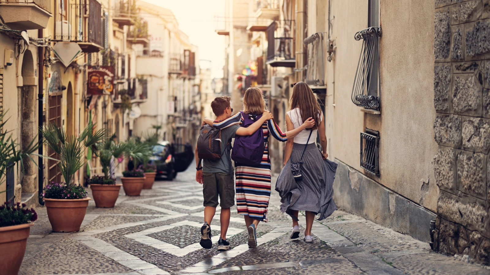 Mother and teenage kids sightseeing beautiful Italian town of Cefalu, Sicily