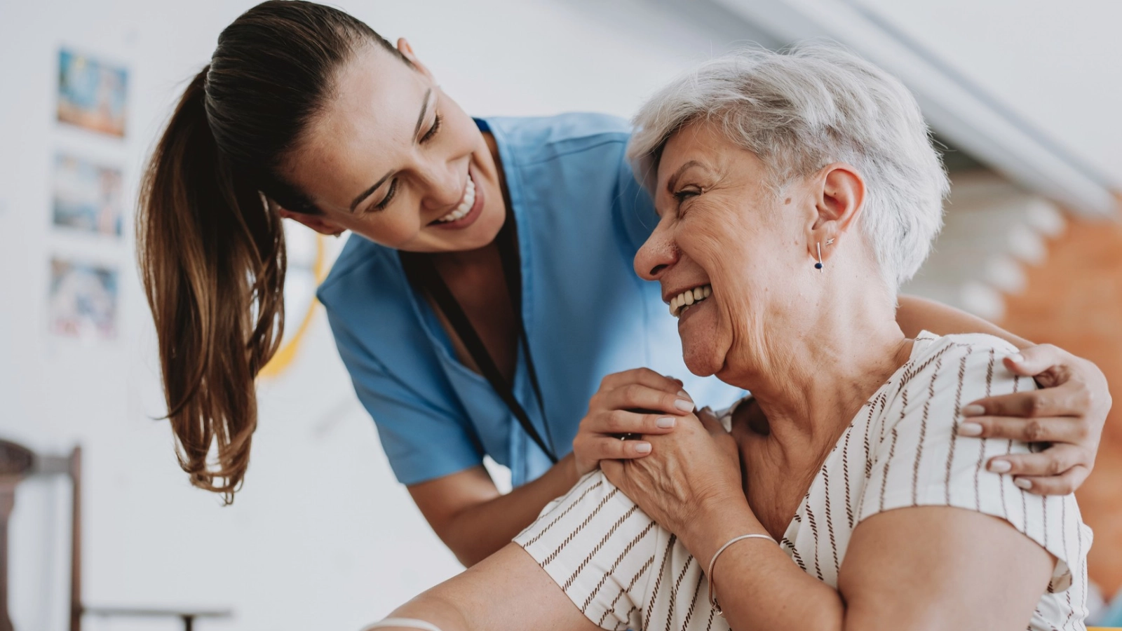 Home care healthcare professional hugging senior patient