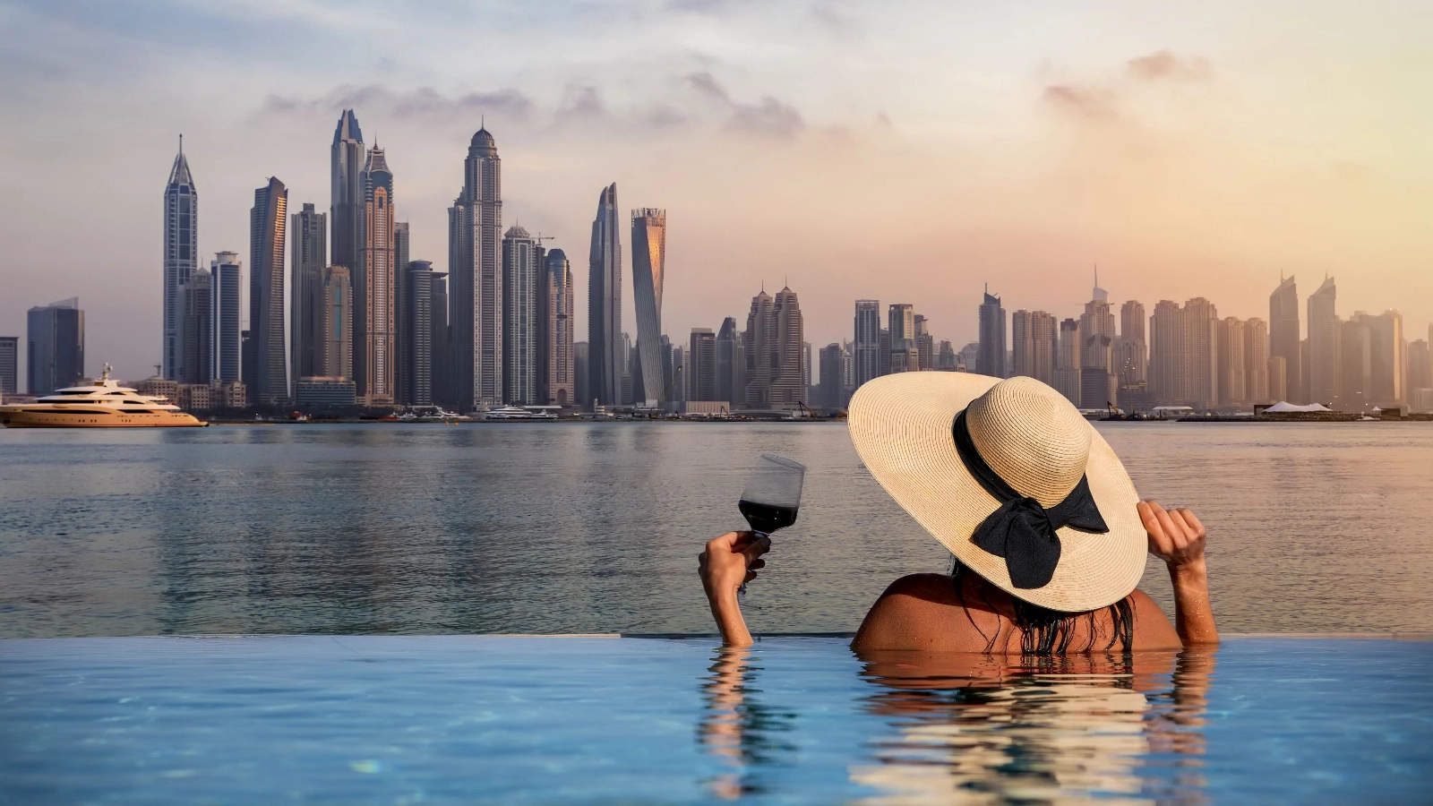 A woman stands at the edge of a pool and enjoys the view