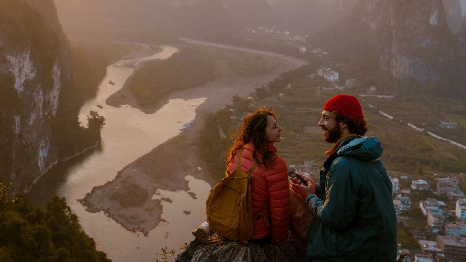 Woman and man looking at panorama of Yanghuo town and river in Guilin, China 