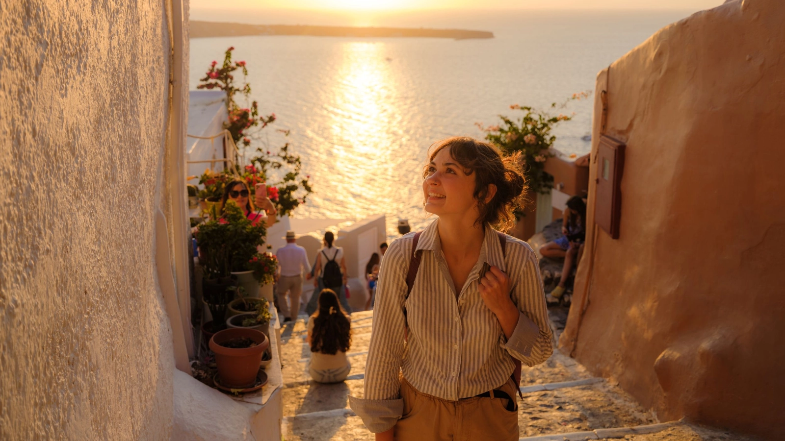 Woman walking on streets on Santorini island at sunset