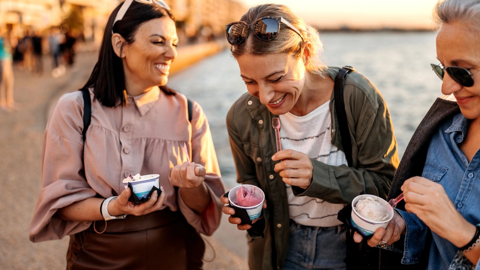Female tourists having ice cream by the sea