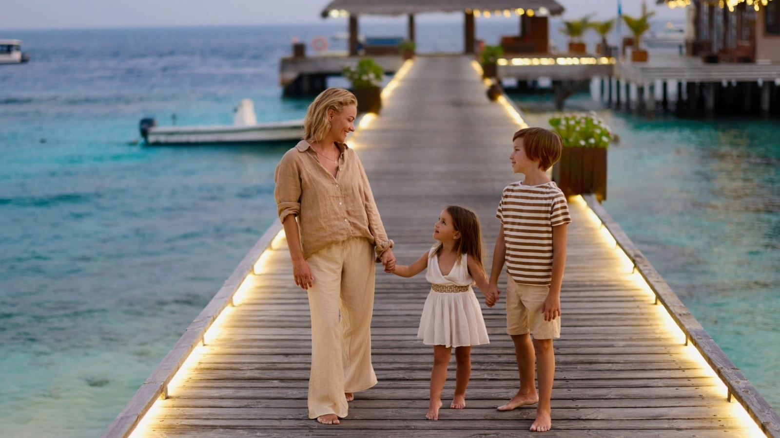 Mother and her kids talking on jetty at the beach