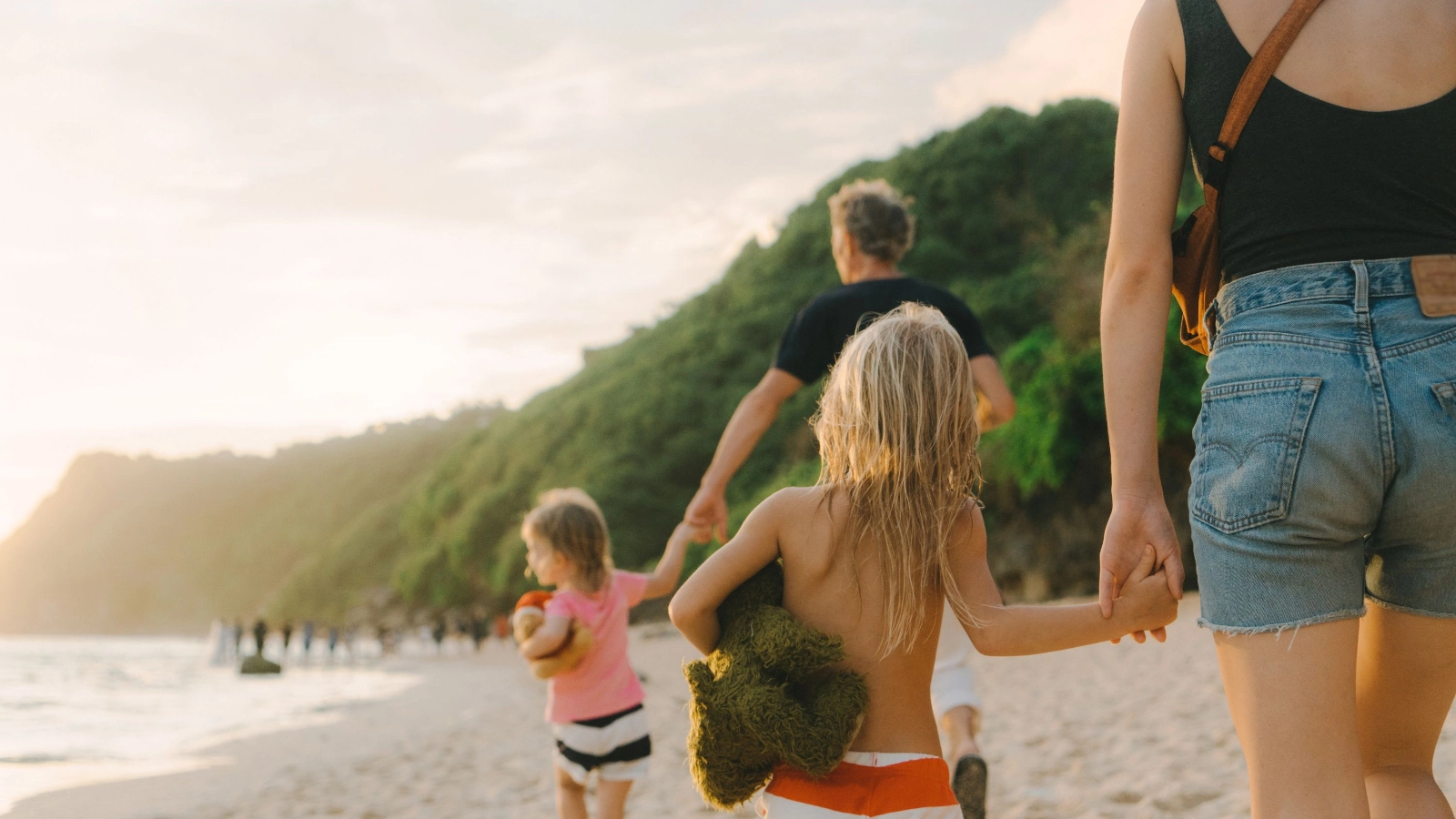 Family with two daughters walking on the beach in Bali