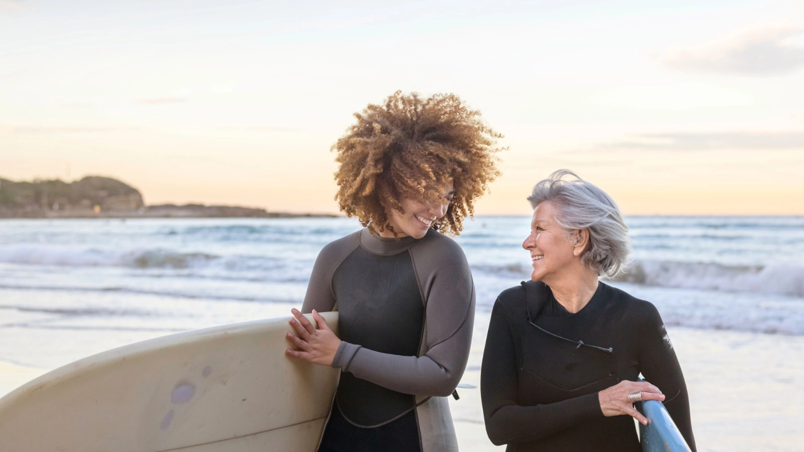 Two women surfing together at the beach