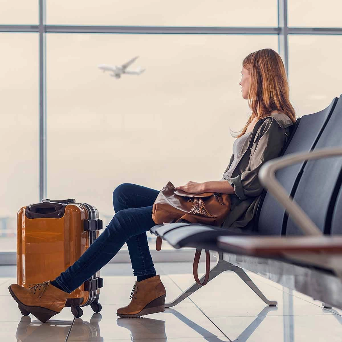 Woman sitting in an airport with luggage